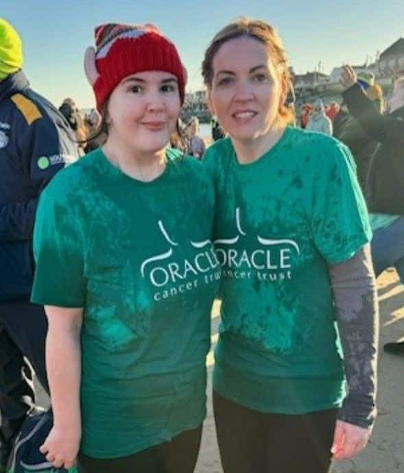 Caroline and Ann wearing Oracle TShirt wet, looking cold but happy at the beach